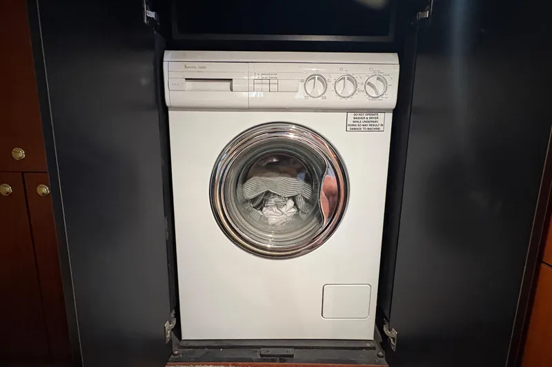 Empty Pockets Yacht Photos Pics Washing machine inside 1999 Sea Ray 460 Sundancer yacht, with clothes visible through door.