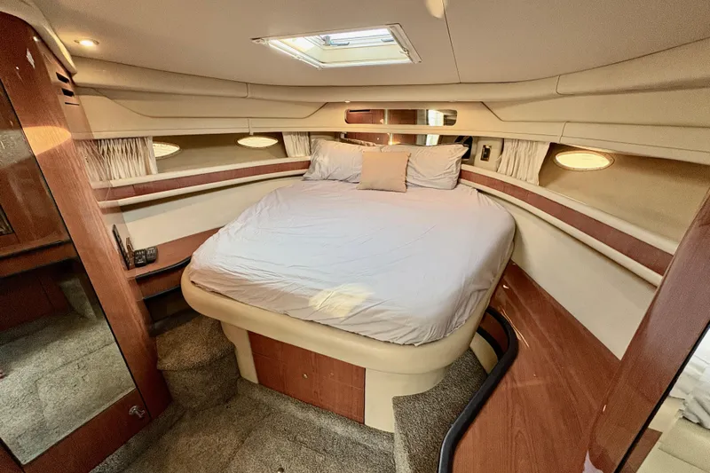 Empty Pockets Yacht Photos Pics Luxurious cabin interior of 1999 Sea Ray 460 Sundancer yacht with cozy bed and elegant wood finish.