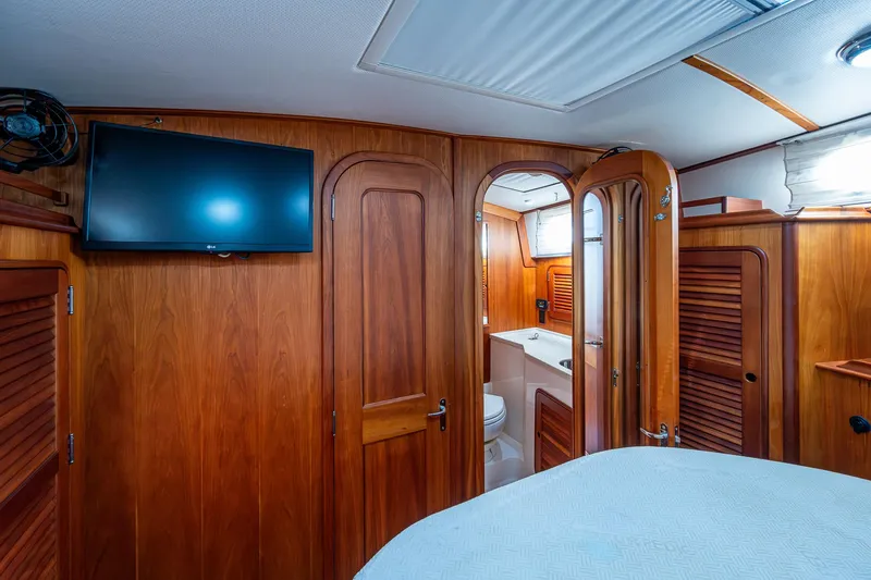 Lionheart Yacht Photos Pics Hinckley Talaria 44 FB 2008 yacht interior with wood paneling, TV, and bathroom.