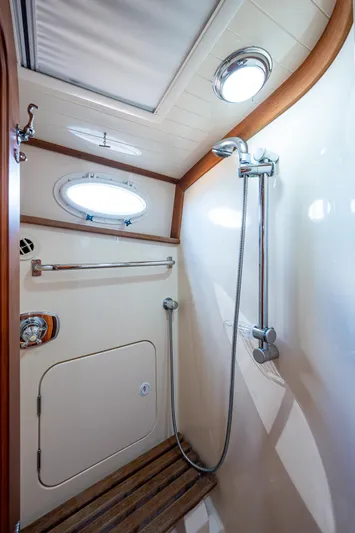 Lionheart Yacht Photos Pics Shower area in 2008 Hinckley Talaria 44 FB yacht with wooden accents and porthole window.