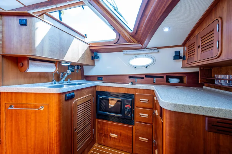Lionheart Yacht Photos Pics Luxurious 2008 Hinckley Talaria 44 FB yacht kitchen with wood cabinetry and modern appliances.