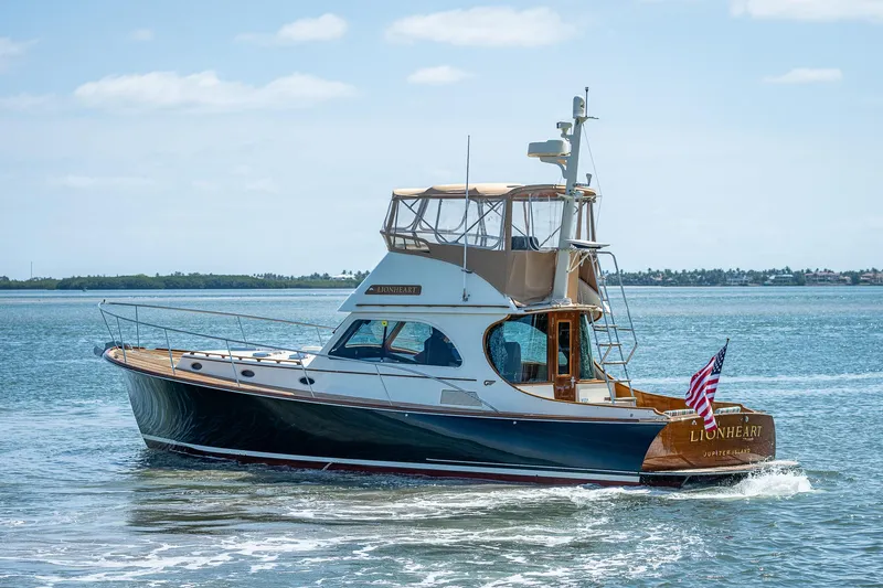 Lionheart Yacht Photos Pics 2008 Hinckley Talaria 44 FB yacht cruising on open water with American flag.