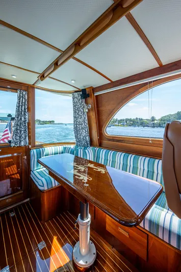 Lionheart Yacht Photos Pics Interior of 2008 Hinckley Talaria 44 FB yacht with striped seating and polished wood table.