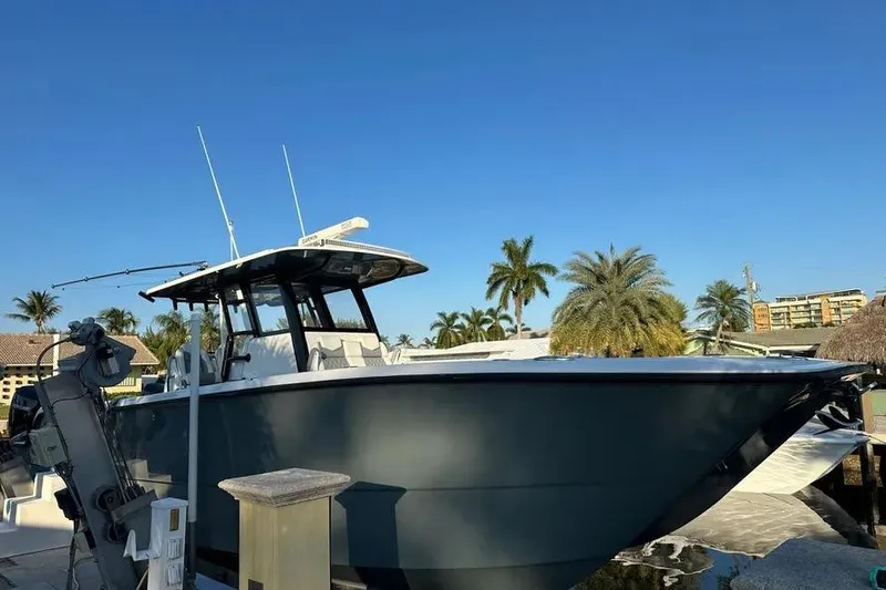  Yacht Photos Pics 2022 Invincible 35 Catamaran docked, surrounded by palm trees under clear blue sky.