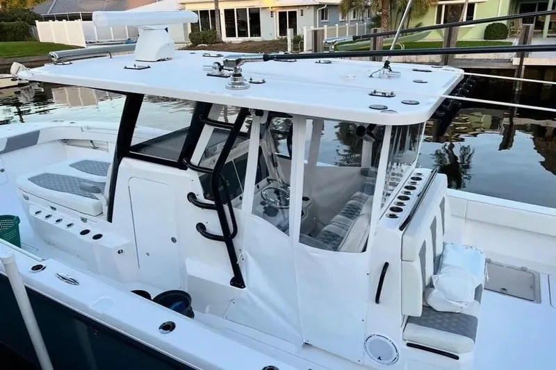  Yacht Photos Pics 2022 Invincible 35 Catamaran with sleek design, docked by waterfront homes.