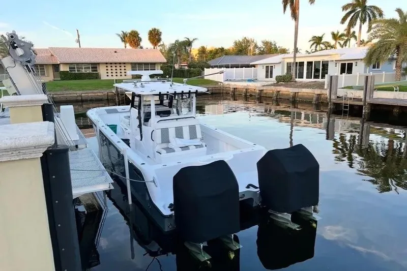  Yacht Photos Pics 2022 Invincible 35 Catamaran docked in a serene residential canal setting.