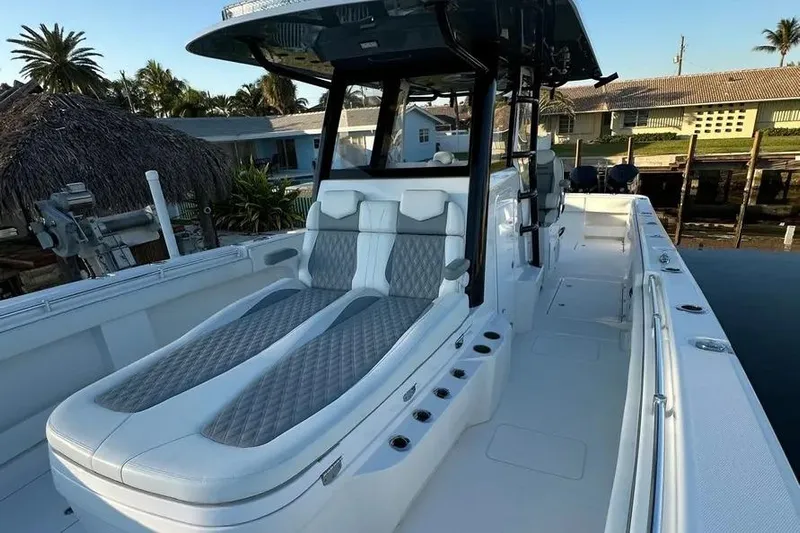  Yacht Photos Pics 2022 Invincible 35 Catamaran with luxurious seating, docked near waterfront homes.