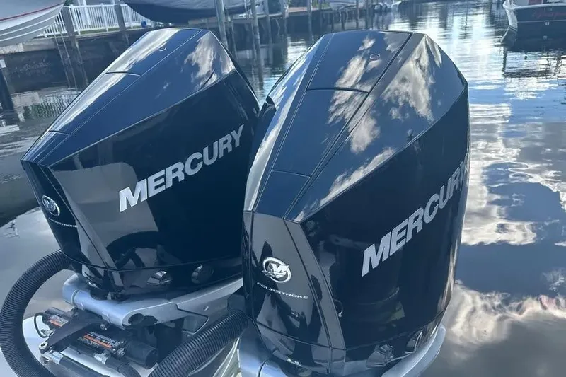  Yacht Photos Pics Twin Mercury outboard engines on a 2022 Invincible 35 Catamaran, reflecting sky and water.