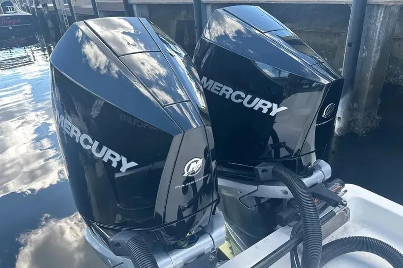  Yacht Photos Pics Twin Mercury outboard engines on a 2022 Invincible 35 Catamaran, reflecting sky and water.