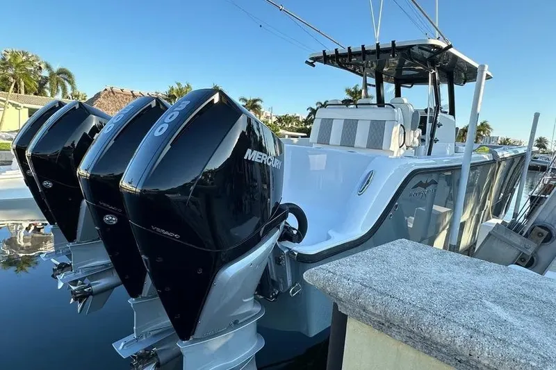  Yacht Photos Pics 2022 Invincible 35 Catamaran with triple Mercury outboard engines docked in a marina.