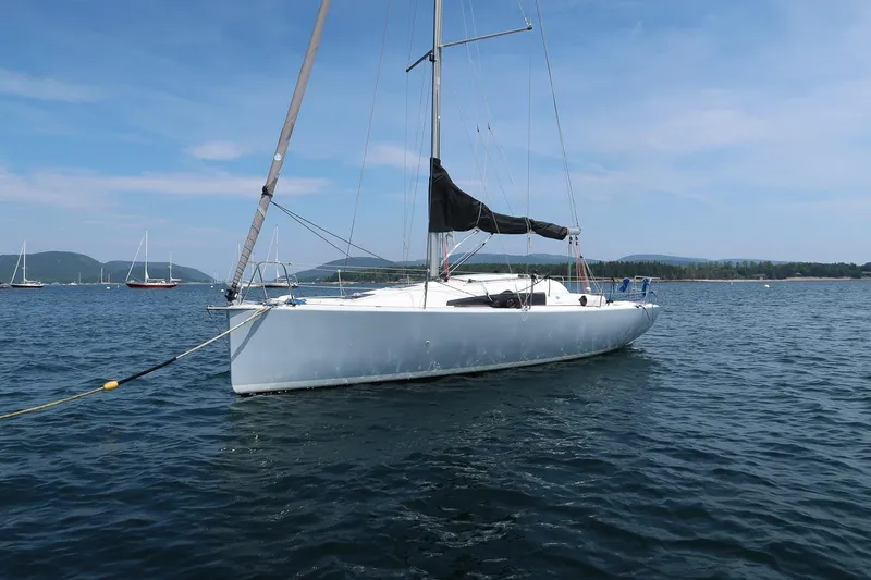 From Away Yacht Photos Pics 2017 Jeanneau SunFast 3200 sailboat anchored on calm water under a clear blue sky.