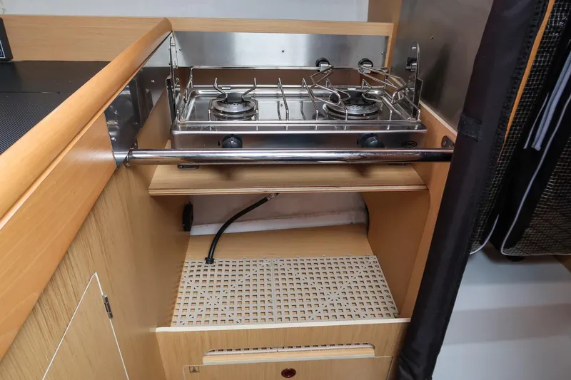 From Away Yacht Photos Pics Compact kitchen area with a two-burner stove on a 2017 Jeanneau SunFast 3200 sailboat.
