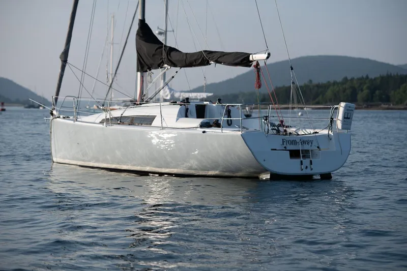 From Away Yacht Photos Pics 2017 Jeanneau SunFast 3200 sailboat on calm water, scenic mountain backdrop.