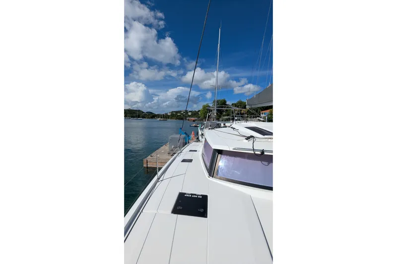 Wanderlust Yacht Photos Pics Fountaine Pajot Saona 47 catamaran docked, 2020 model, under clear blue sky.
