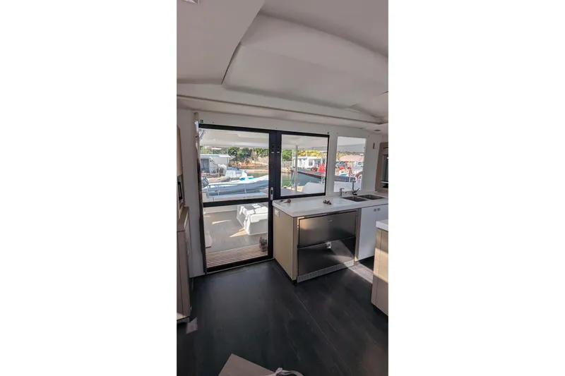Wanderlust Yacht Photos Pics Interior view of 2020 Fountaine Pajot Saona 47 yacht, featuring modern kitchen and outdoor access.