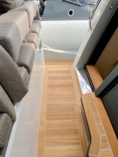 Seayou Yacht Photos Pics 2022 SACS Strider 15 boat interior with wooden flooring and cushioned seating.