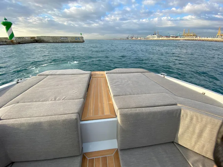 Seayou Yacht Photos Pics 2022 SACS Strider 15 boat with cushioned deck, overlooking a calm sea and cloudy sky.