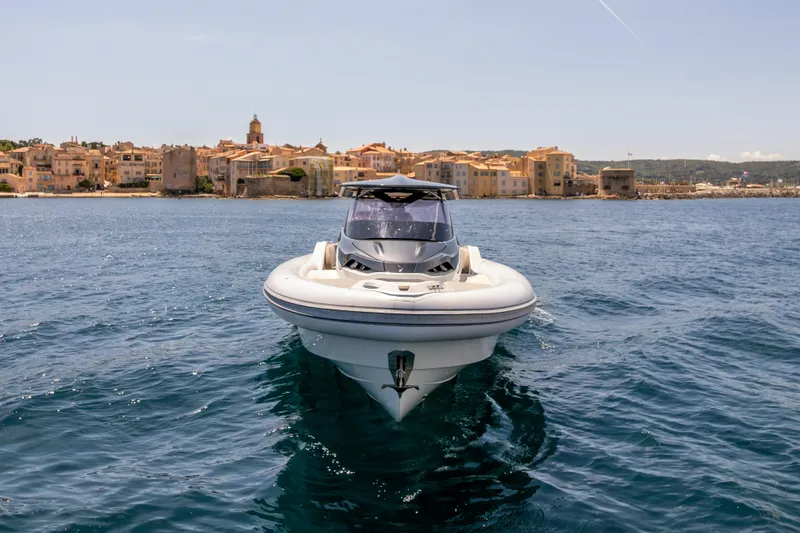 Seayou Yacht Photos Pics 2022 SACS Strider 15 boat on water, with coastal town in background.