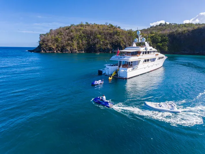 Lady J Yacht Photos Pics Palmer Johnson 1997 Motor Yacht anchored in a scenic bay with jet skis.