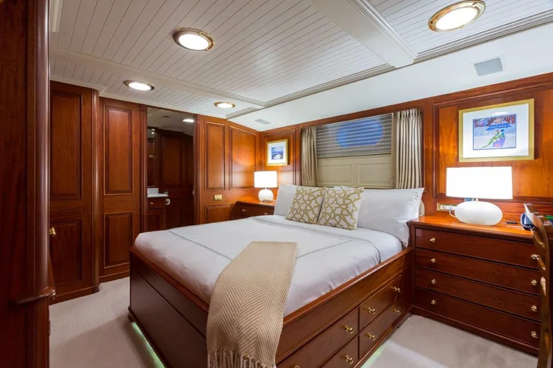 Lady J Yacht Photos Pics Luxurious 1997 Palmer Johnson motor yacht bedroom with elegant wood paneling and cozy lighting.