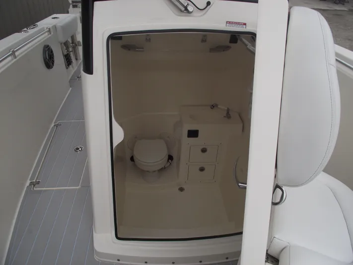  Yacht Photos Pics 2021 Cobia 301 Center Console boat interior with compact bathroom and sink.