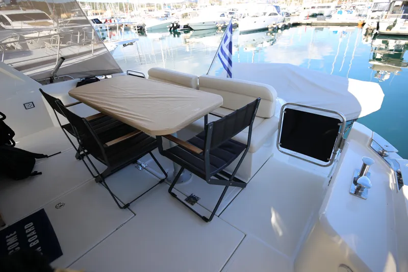  Yacht Photos Pics 2023 Greenline 45 Coupe yacht deck with table, chairs, and marina view.