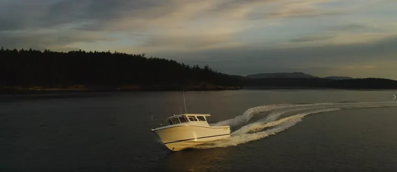  Yacht Photos Pics 2025 Ocean Sport Roamer cruising on a serene lake at sunset.
