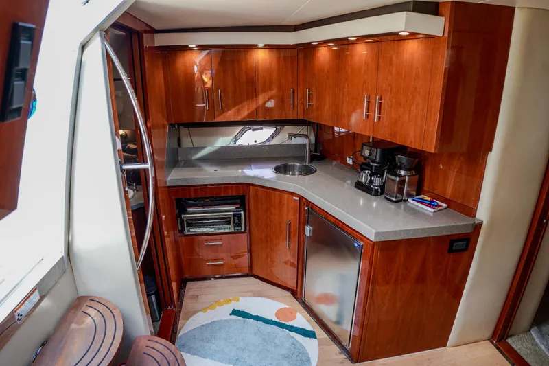  Yacht Photos Pics Luxurious 2012 Regal 42 Sport Coupe yacht kitchen with modern appliances and sleek wood cabinetry.