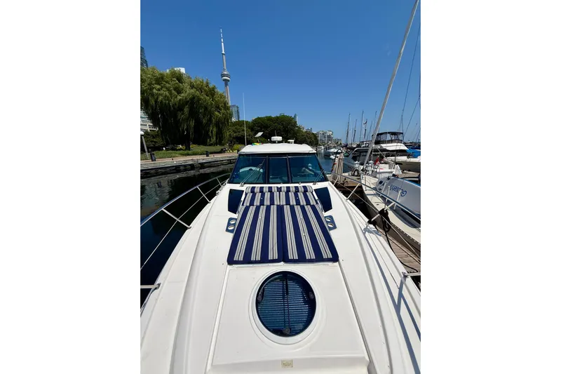  Yacht Photos Pics 2012 Regal 42 Sport Coupe yacht docked, with city skyline and clear blue sky.