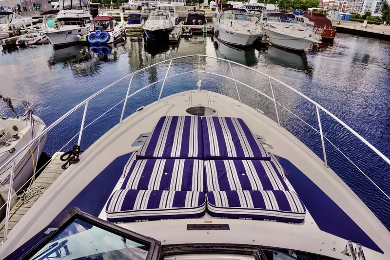  Yacht Photos Pics 2012 Regal 42 Sport Coupe yacht with striped sun pads docked in a marina.