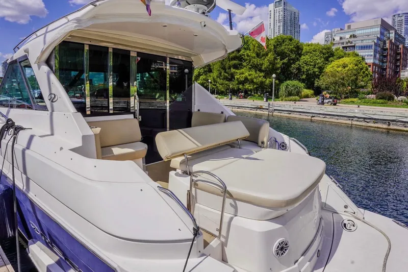  Yacht Photos Pics 2012 Regal 42 Sport Coupe yacht docked by urban waterfront with lush greenery.