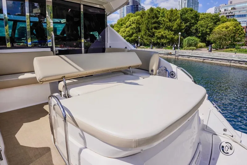  Yacht Photos Pics 2012 Regal 42 Sport Coupe yacht with spacious sun deck, docked by lush greenery.