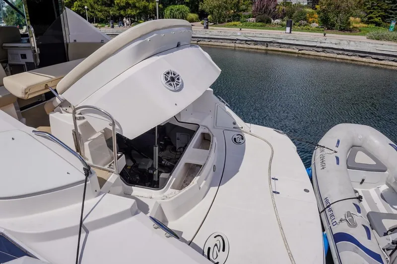  Yacht Photos Pics 2012 Regal 42 Sport Coupe yacht with open engine compartment, docked beside an inflatable boat.