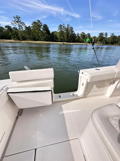  Yacht Photos Pics 2019 Jupiter 30 HFS boat interior with fishing rod, near calm waters and forested shoreline.