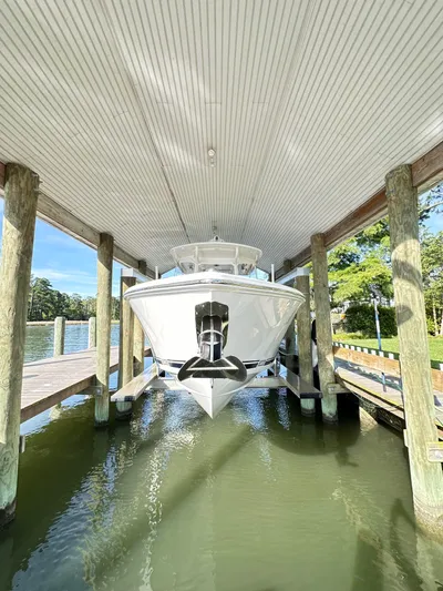 Yacht Photos Pics 2019 Jupiter 30 HFS boat docked under covered structure on calm water.