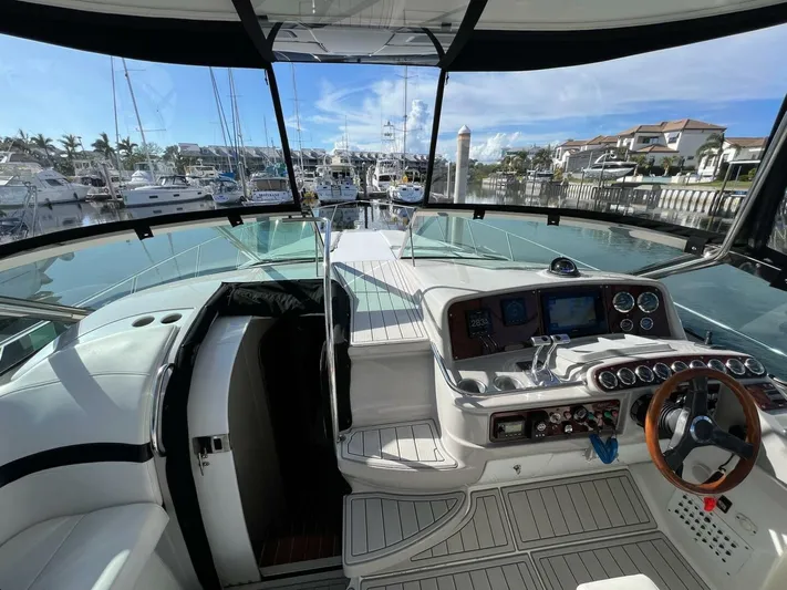 Happy Ours Yacht Photos Pics 2005 Formula 40 PC yacht cockpit with marina view, featuring modern controls and luxurious seating.