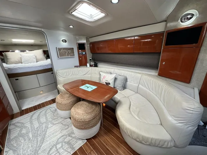 Happy Ours Yacht Photos Pics 2005 Formula 40 PC yacht interior with plush seating, wooden table, and cozy bedroom.