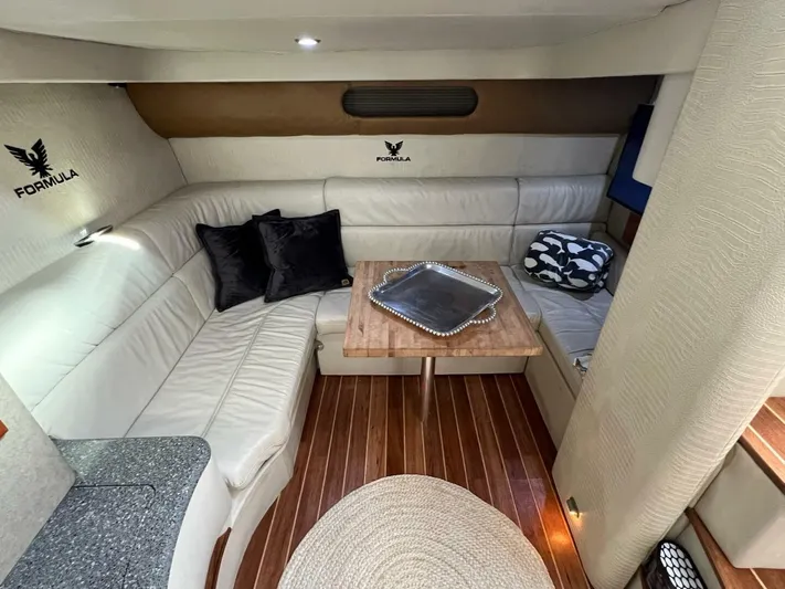 Happy Ours Yacht Photos Pics Interior of 2005 Formula 40 PC yacht with elegant seating and wooden table.