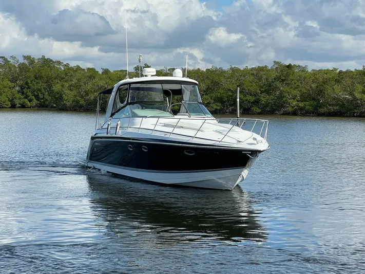 Happy Ours Yacht Photos Pics 2005 Formula 40 PC yacht cruising on a calm river with lush greenery.