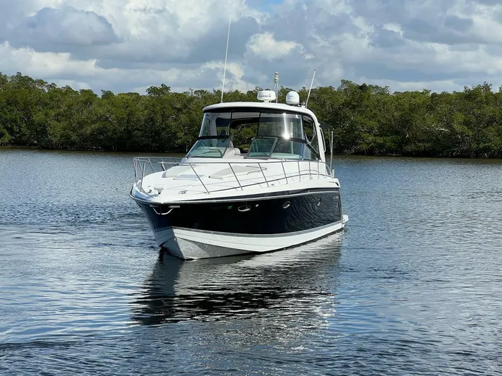 Happy Ours Yacht Photos Pics 2005 Formula 40 PC boat cruising on a calm lake under a cloudy sky.