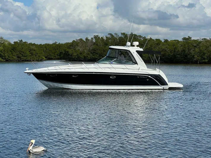 Happy Ours Yacht Photos Pics 2005 Formula 40 PC yacht on calm water with lush green background.