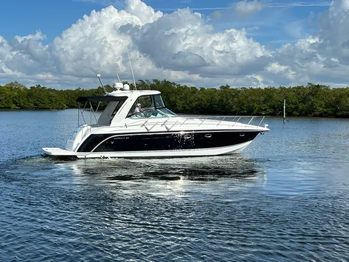 Happy Ours Yacht Photos Pics 2005 Formula 40 PC yacht cruising on a calm lake under a cloudy sky.