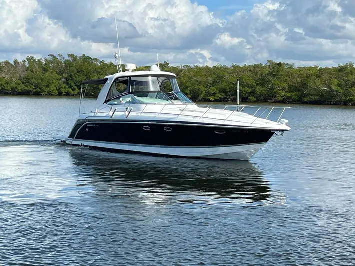 Happy Ours Yacht Photos Pics 2005 Formula 40 PC yacht cruising on a calm lake with lush greenery.