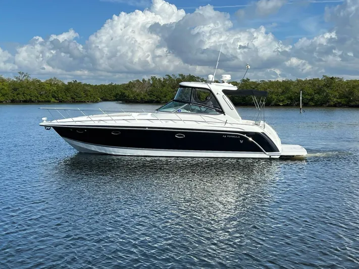 Happy Ours Yacht Photos Pics 2005 Formula 40 PC yacht cruising on calm water under a partly cloudy sky.