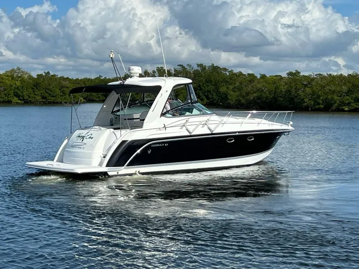 Happy Ours Yacht Photos Pics 2005 Formula 40 PC yacht cruising on a calm lake under a cloudy sky.