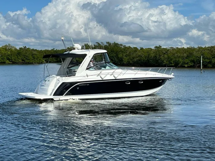 Happy Ours Yacht Photos Pics 2005 Formula 40 PC yacht cruising on a calm lake under a partly cloudy sky.