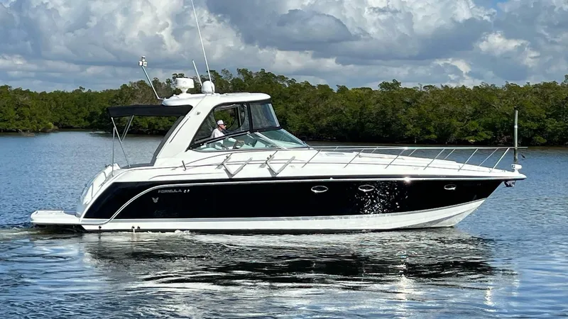 Happy Ours Yacht Photos Pics 2005 Formula 40 PC yacht cruising on a calm lake under a cloudy sky.