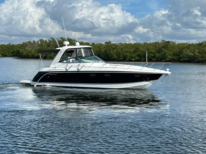 Happy Ours Yacht Photos Pics 2005 Formula 40 PC yacht cruising on a calm lake under a cloudy sky.