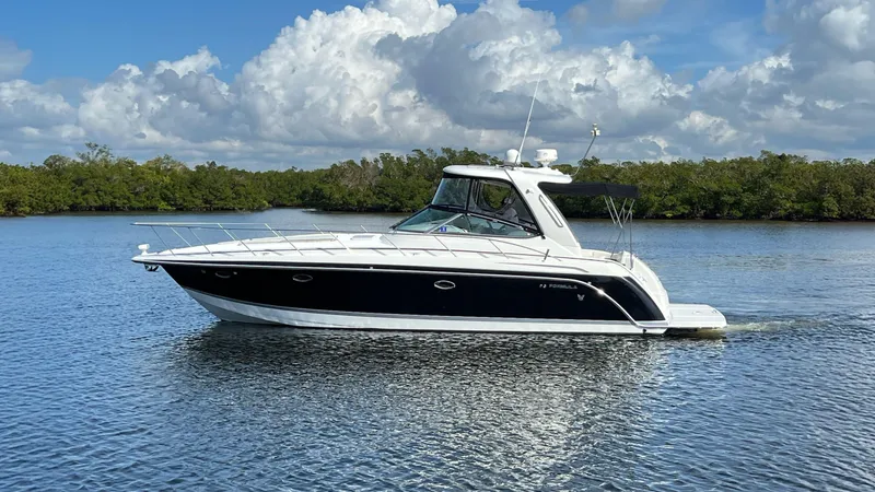 Happy Ours Yacht Photos Pics 2005 Formula 40 PC yacht cruising on a serene lake under a partly cloudy sky.