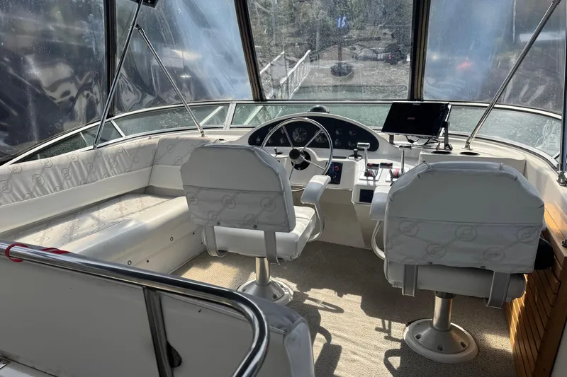 Lost Together Yacht Photos Pics 1996 Bayliner 4087 Aft Cabin Motoryacht helm with white seating and navigation controls.